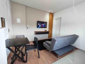 a room with a desk and a table and chairs at Apartamento Maravilhoso para Casal em São Roque in São Roque