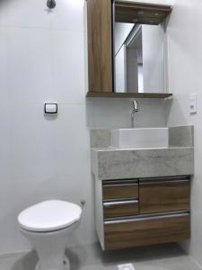 a bathroom with a toilet and a sink and a mirror at Apartamento Maravilhoso para Casal em São Roque in São Roque