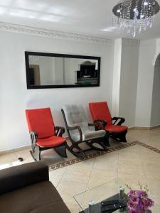 a living room with three chairs and a mirror at acogedor apartamento moderno in Barranquilla