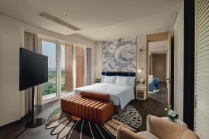 a hotel room with a bed and a television at Hotel Indigo Shanghai Harbour City in Nanhui