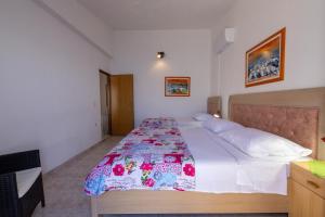 a bedroom with a large bed with a floral bedspread at Apartment Solotisa 4623a in Bogomolje