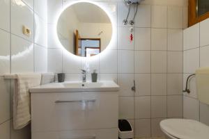 a white bathroom with a sink and a mirror at Apartment Solotisa 4623a in Bogomolje +23 photos