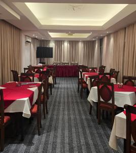 a restaurant with red tables and chairs and a screen at Laurel Lakefront Hotel in Dhaka