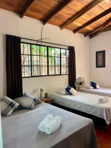 a bedroom with two beds and a large window at Sunrise Guest House in León