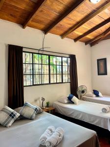 een slaapkamer met twee bedden en een groot raam bij Sunrise Guest House in León