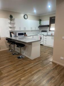 a kitchen with white cabinets and a counter top at Benalla Apartments in Benalla +9 photos