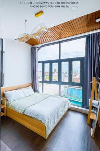 een slaapkamer met een bed en een groot raam bij Khách Sạn MINTNACIE in Phan Rang