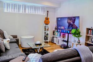 Una sala de estar con un sofá y un televisor de pantalla plana. en Gem OF The Vineyard, Cosy Retreat Near Swan Valley, en Upper Swan