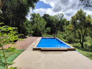 a swimming pool in the middle of a garden at Saltos del Tabay LOGDE in Puerto Leoni