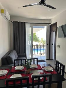 een woonkamer met een tafel, stoelen en een bank bij BigWave Costa Rica in Playa Hermosa