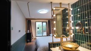a bedroom with a bed and a mirror and a sink at Xinyu Hotel - Shanghai Jiao Tong University Xinhua Road in Shanghai