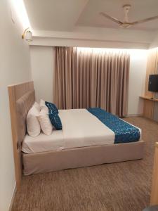 a hotel room with a bed with blue and white pillows at Laurel Lakefront Hotel in Dhaka +36 photos