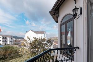 a balcony with a view of a house at An Nhiên Hotel & Villa Da Lat in Khu Chi Lăng