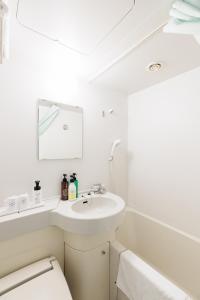 名古屋市にある名古屋栄グリーンホテルの洗面台とトイレを備えた白いバスルーム