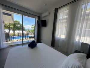een slaapkamer met een bed en een groot raam bij BigWave Costa Rica in Playa Hermosa