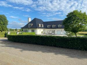 RingeにあるManor House Overlooking Fields And Gardenの黒い屋根の大きな白い家