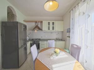 una cocina con una mesa y un refrigerador en Apartments with parking space Postira, Brac - 11582, en Postira 12 fotos más