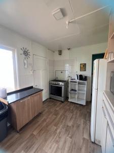 a kitchen with a stove and a refrigerator at Casas Punta Arenas in Punta Arenas
