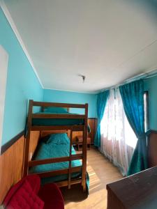 a bedroom with two bunk beds and a window at Casas Punta Arenas in Punta Arenas