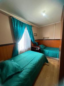 a bedroom with two beds and a window at Casas Punta Arenas in Punta Arenas