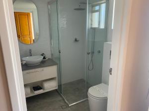 a bathroom with a shower and a toilet and a sink at McNevins Maryborough Motel in Maryborough