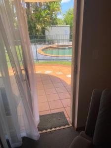 an open door with a view of a tennis court at McNevins Maryborough Motel in Maryborough