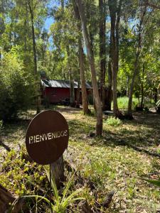 a sign in the grass in front of a cabin at Galilea in San Miguel del Monte
