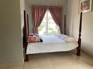 una cama en una habitación con ventana en Casa Del Mar Apartments, en Brufut