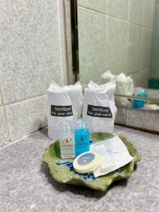 un montón de artículos de tocador en una mesa en el baño en Asian Hotel, en Hat Yai