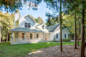 ein weißes Haus mit einer Veranda mit Bäumen in der Unterkunft White Cedar Retreat in Ellison Bay