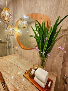 a bathroom with a table with a vase of flowers at la la lay beach house in Tab Kaek Beach