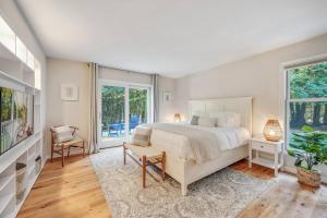 ein Schlafzimmer mit einem Bett und einem Fernseher und Fenstern in der Unterkunft White Cedar Retreat in Ellison Bay