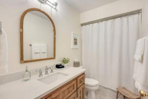 ein Badezimmer mit Waschbecken, Toilette und Spiegel in der Unterkunft White Cedar Retreat in Ellison Bay + 32 Fotos