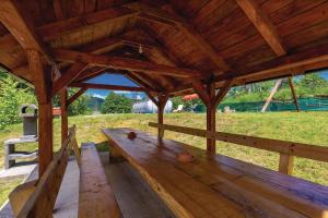 - un pavillon en bois avec un banc dans un champ dans l'établissement Apartments for families with children Jasenak, Gorski kotar - 23804, à Jasenak