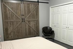 a bedroom with a sliding barn door and a chair at 5 minute walk to the gulf course in San Antonio +30 photos