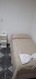 a bed sitting in a room with a white wall at Apart Brumato in Catriel
