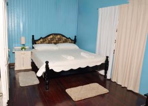 a bedroom with a bed with a blue wall at South Oasis in Georgetown