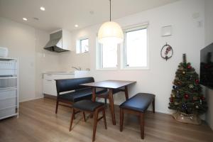 a kitchen with a table and chairs and a christmas tree at La Neige in Makkari