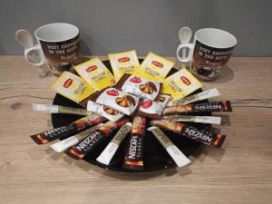 a pile of toothbrushes and candy on a table with two cups at Angelina's Home and Spa Alexandroupolis in Alexandroupoli