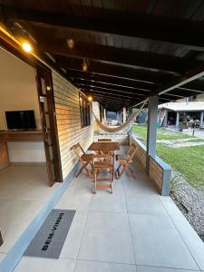 インビトゥバにあるPousada Encantos do Rosaのパティオ(木製テーブル、椅子2脚付) +3枚の写真