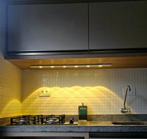 a kitchen with a sink and a stove top at Pousada Encantos do Rosa in Imbituba