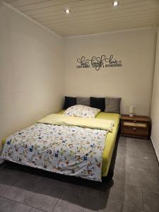 a bedroom with a bed and a sign on the wall at 1-Zimmer Apartment in Oberopfingen