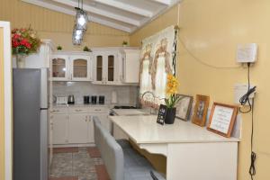 a kitchen with white cabinets and a table with chairs at South Oasis in Georgetown