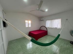 a hammock in a room with a bed and a window at Casa Tortuga in Chelem +3 photos