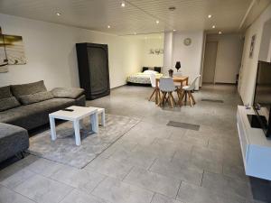 a living room with a couch and a table at 1-Zimmer Apartment in Oberopfingen