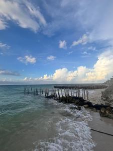 a beach with a pier in the water at Casa Tortuga in Chelem