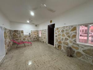 a room with a stone wall and a pink bench at Casa Tortuga in Chelem