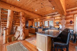a log cabin kitchen with a large center island at Heron Chalet by Outpost Whistler in Whistler