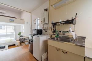 a kitchen with a sink and a refrigerator at Chihaya Relaxation Haven in Fukuoka