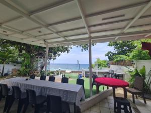 a patio with a table and chairs and the ocean at White beach Villa in Panglao Island